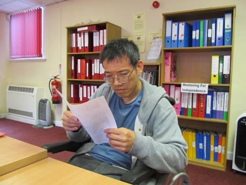 Photo showing Wai reading an interview schedule